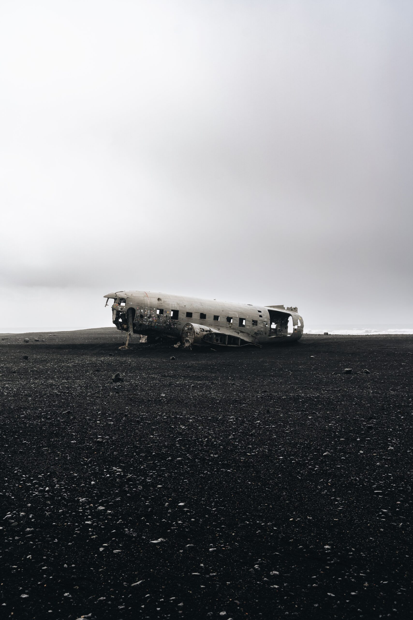 A mesmerizing view of a plane wreck on a stunning black sand beach captured by Djordje Vukojicic Photography.