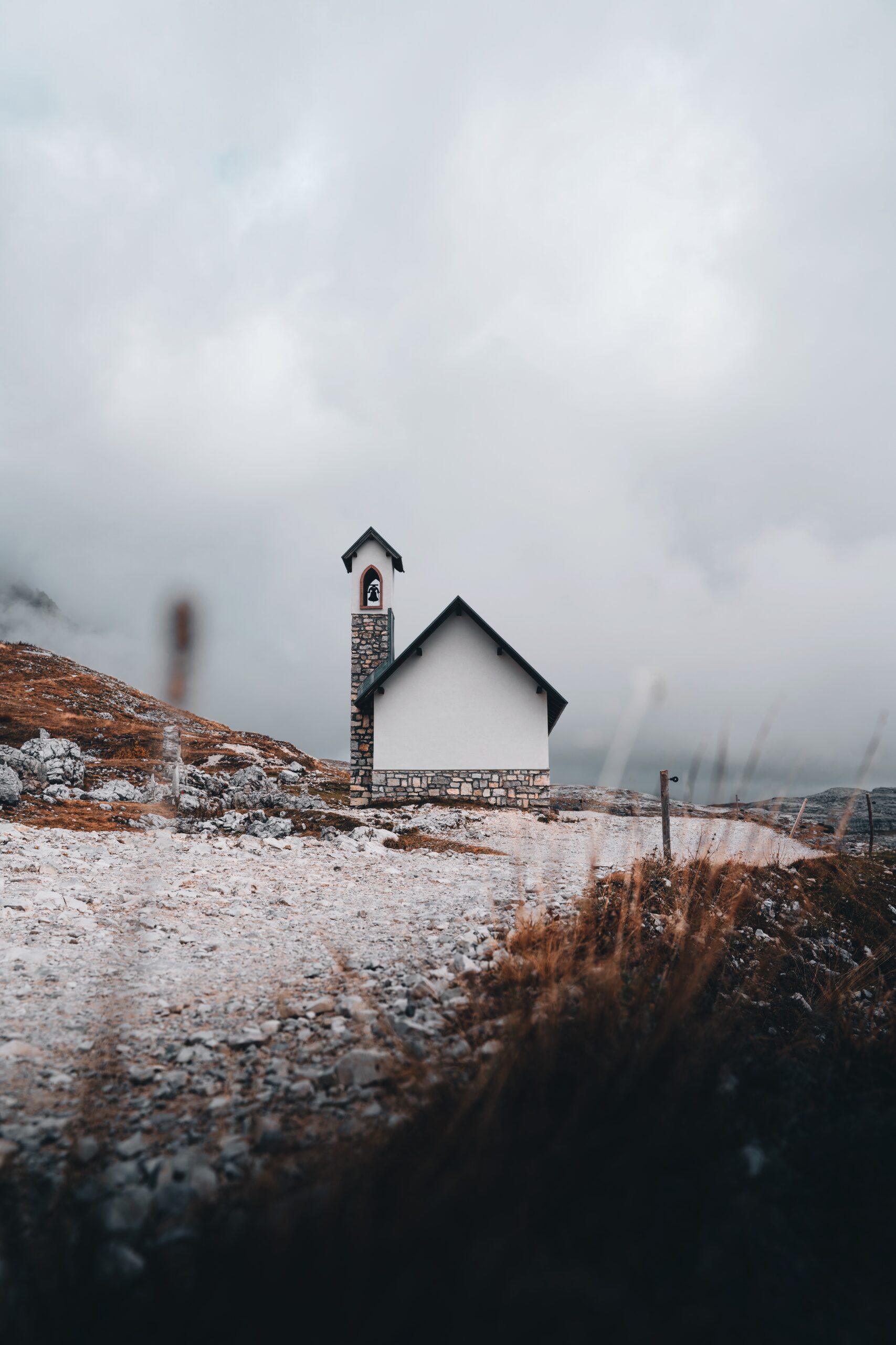 Discover the charm of the Dolomites through the lens of Djordje Vukojicic Photography, featuring a quaint church perched on a hill against the breathtaking backdrop of the mountains.