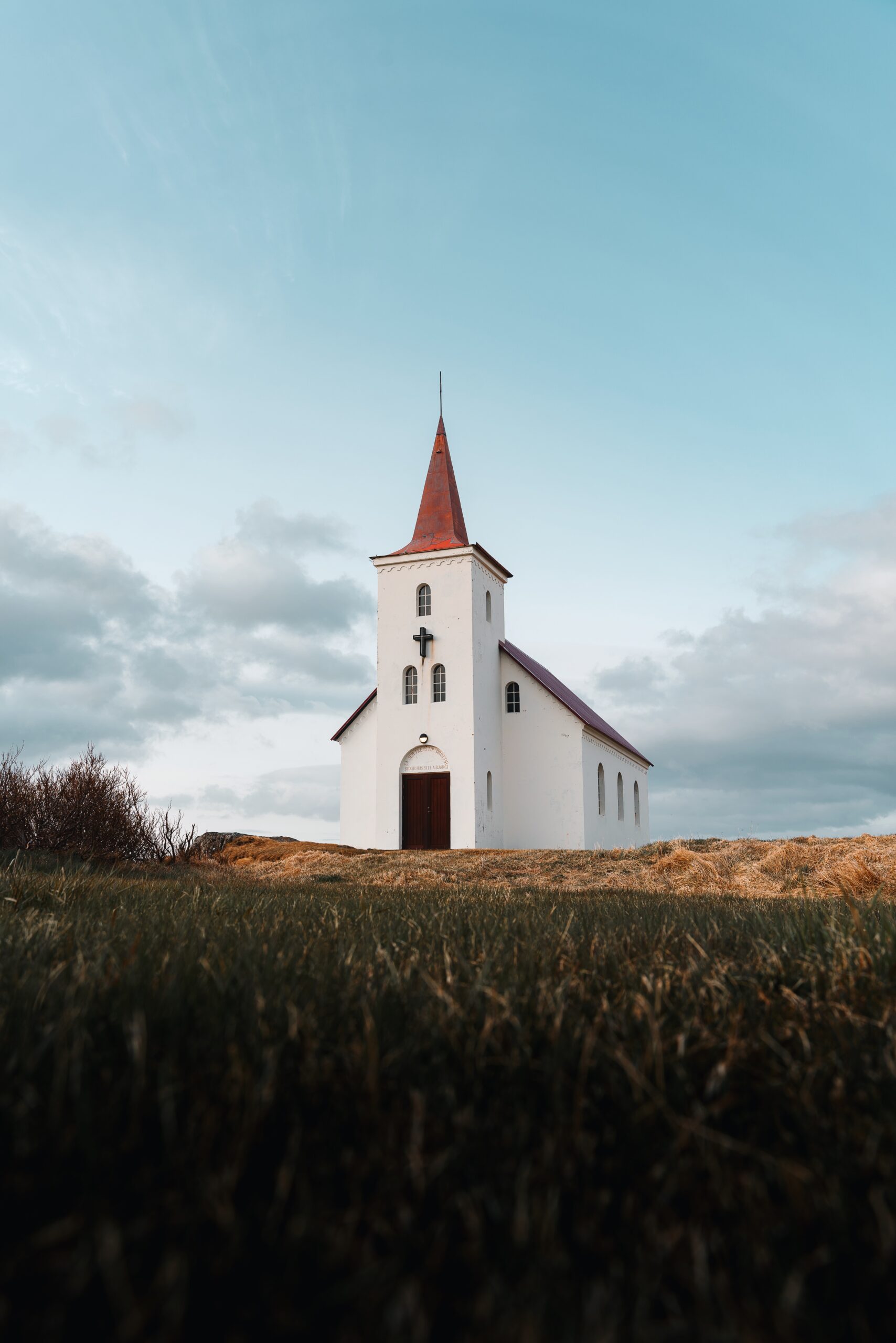 Djordje Vukojicic Photography captures architectural grace - a white church with a distinctive red roof set against a serene backdrop.